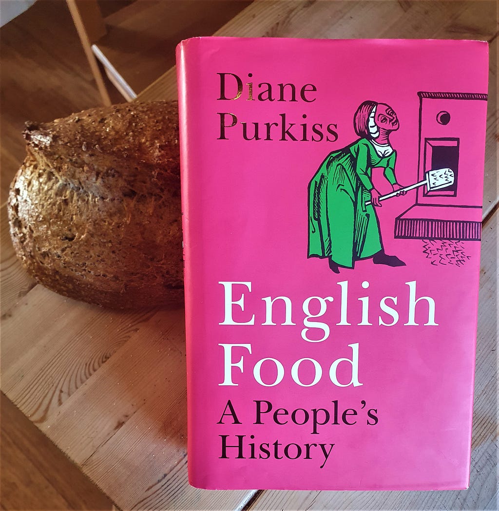 Book of “English Food” with a loaf of bread on simple wooden table. Picture by Edward Breen, 2023.