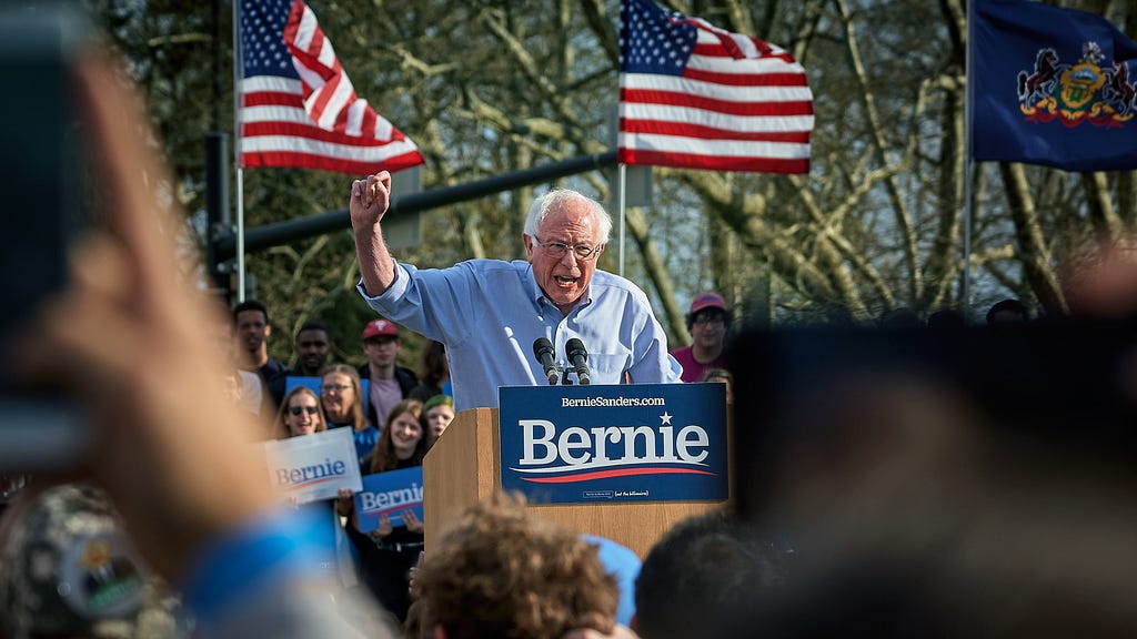 bernie sanders, podium, campaign rally, american flags