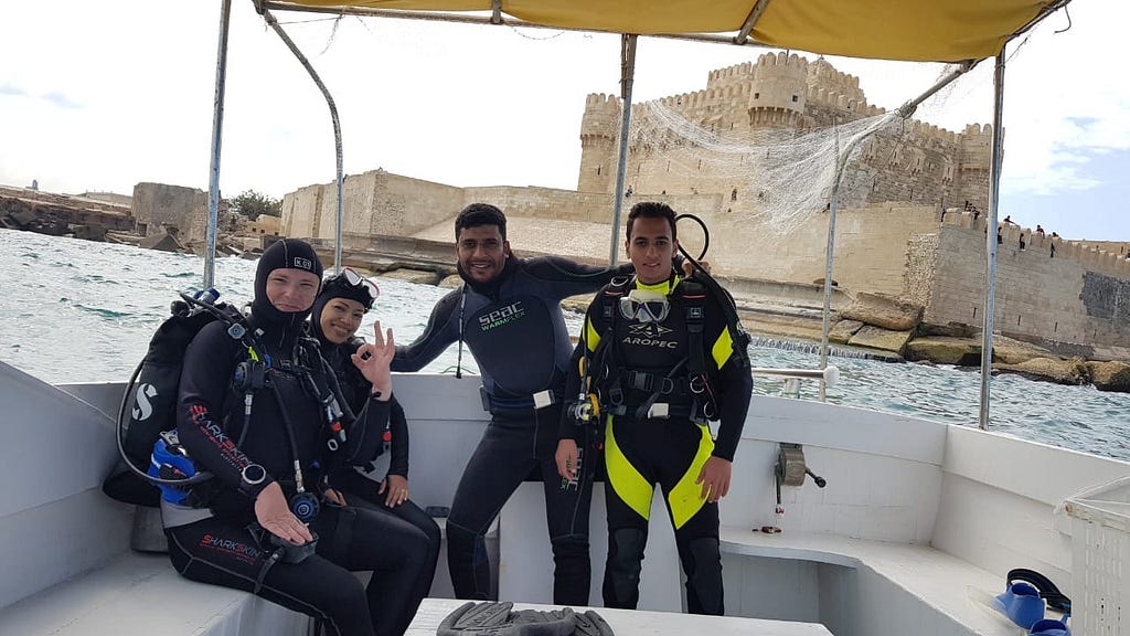 Scuba divers on a boat with a castle in the background