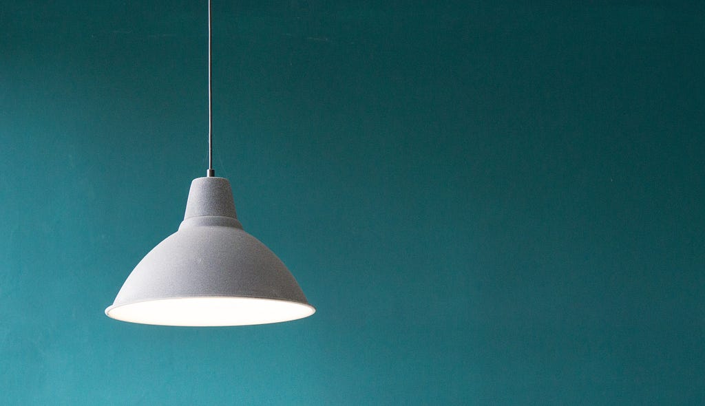 A hanging lamp with a turquoise background