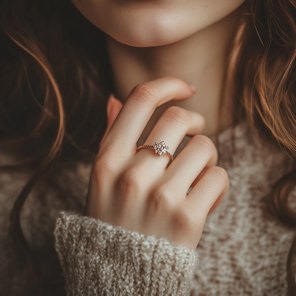 a close up shot of a young lady’s hand with a ring on her finger