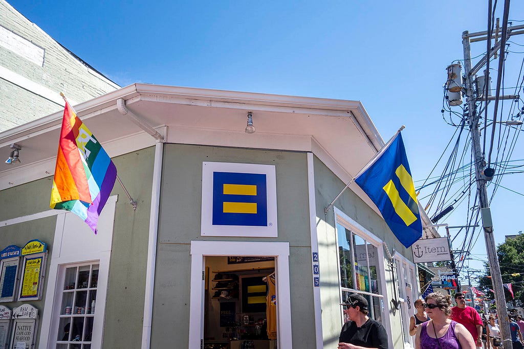 a green storefront with flags indicating lgbtq friendly