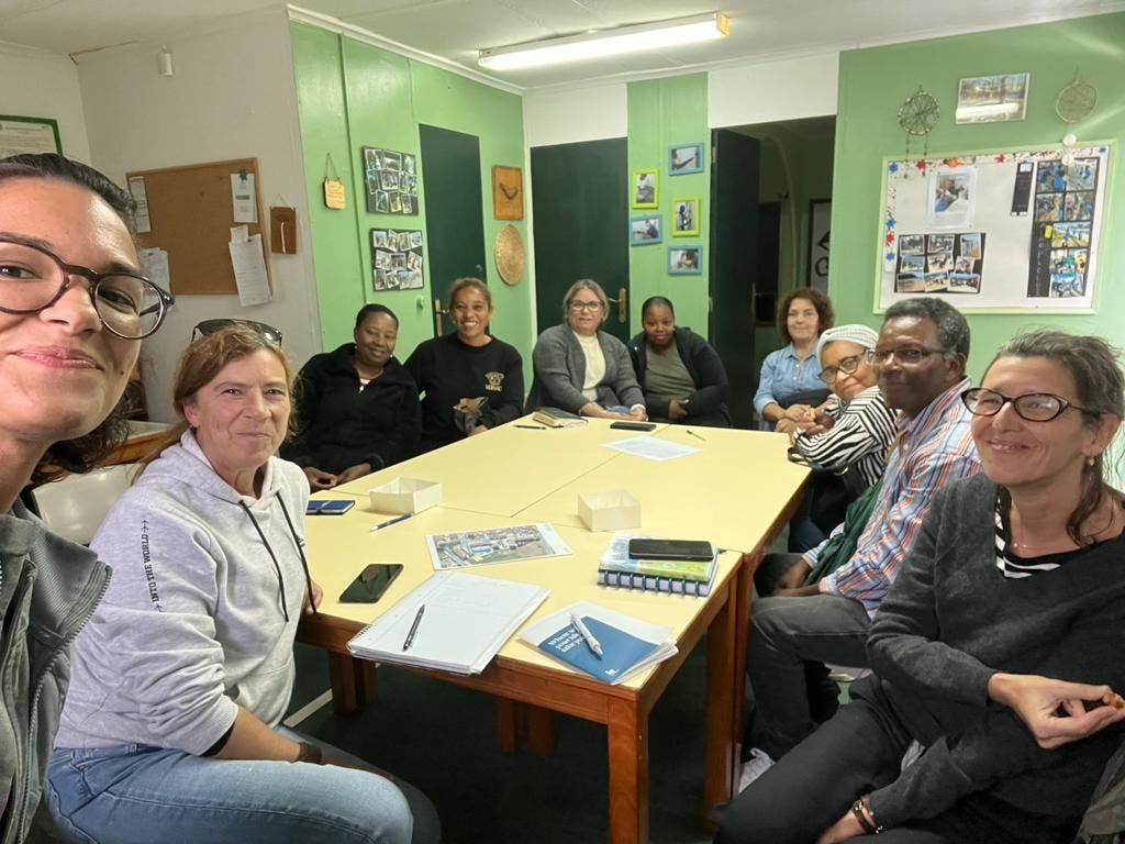 Group of Cascais community leaders smiling around a table, posed for a selfie.