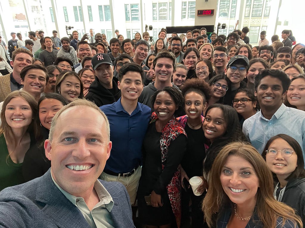 A group selfie, with Bret Taylor in the foreground and dozens of interns in the background. There’s a diverse mix of people.