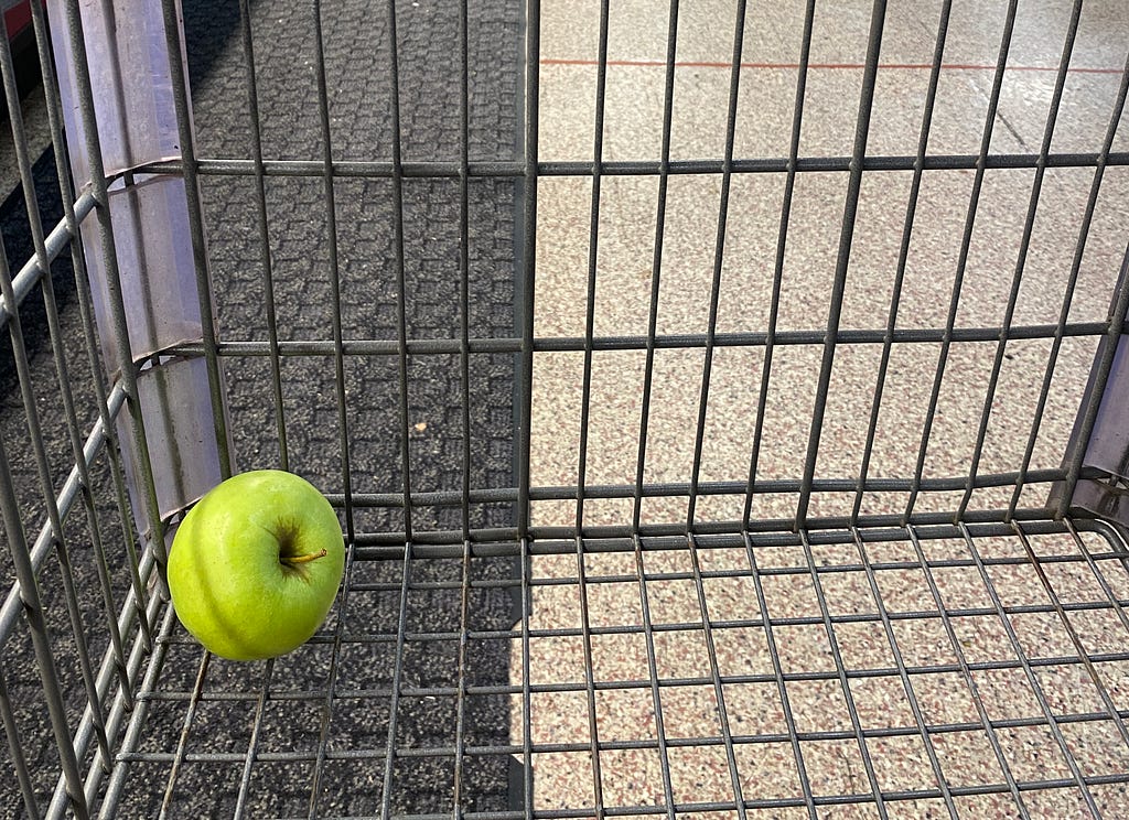 Single green apple in a shopping cart. Photo by Dori Walker/RAND Corporation