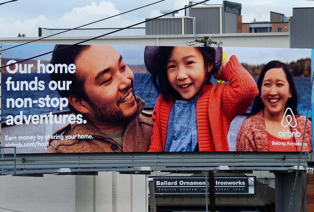 An Airbnb billboard ad displaying a family smiling