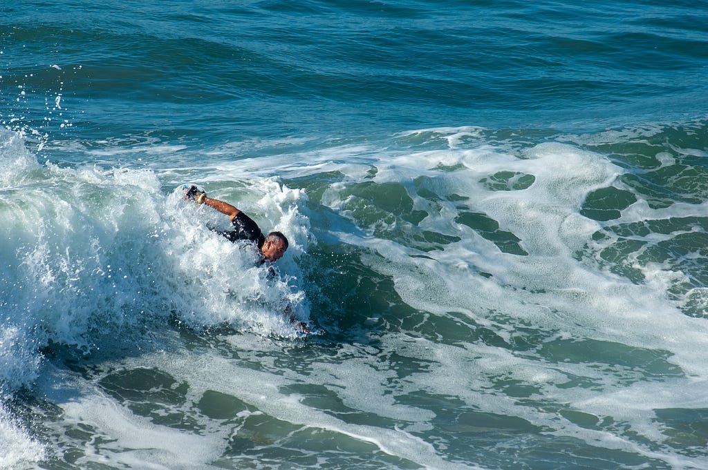 Man bodysurfing a wave in the ocean.