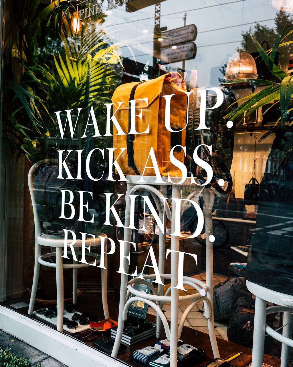 A window etching sign is displayed for passerbys to see and read, which reads: “Wake Up. Kick Ass. Be Kind. Repeat.”