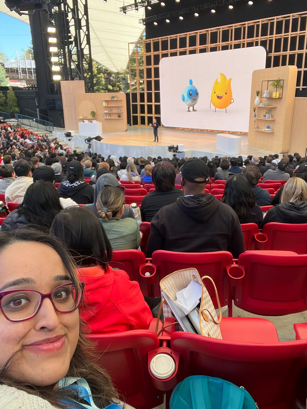 A selfie of me with the stage screen displaying Flutter and Firebase mascots