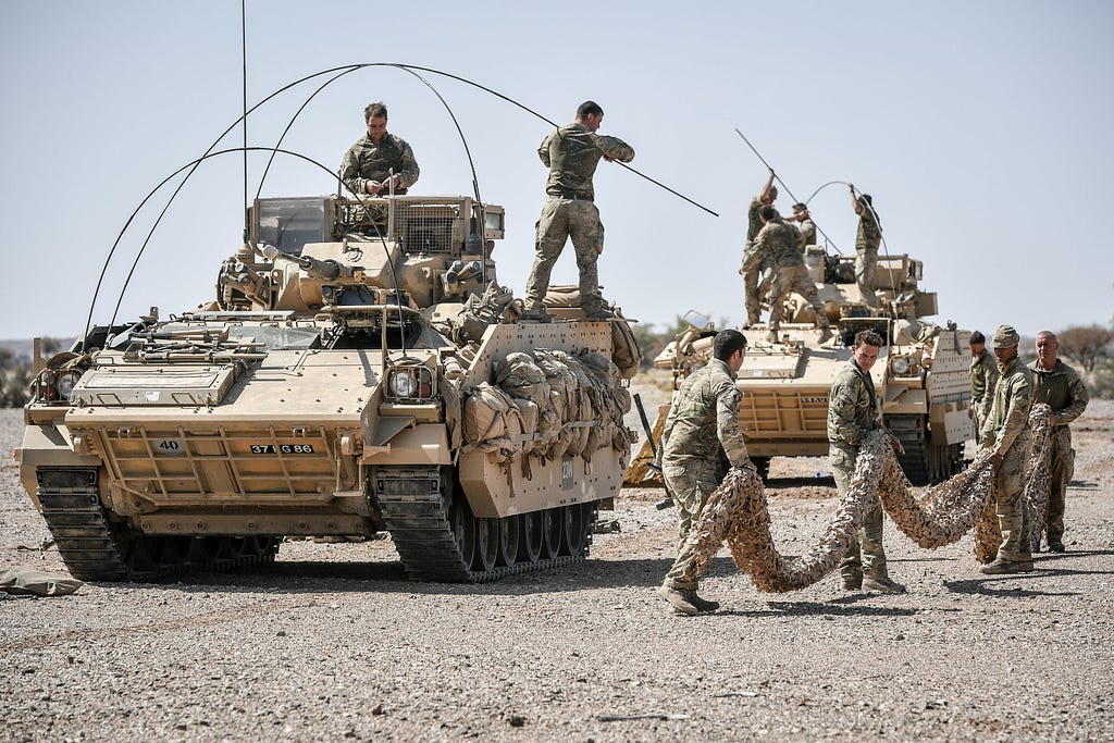 A Warrior armoured fighting vehicle crew prepares to camouflage its wagon in the Oman desert, where UK forces are taking part in a month-long exercise, Saif Sareea 3, October 8, 2018. Photo by Ben Birchall/PA Images via Reuters