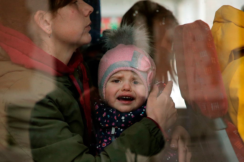 A Ukrainian refugee child reacts as he boards a bus after arriving at Hendaye train station, southwestern France, Wednesday, March 9, 2022. About 200 Ukrainian refugees are arriving in the French Atlantic coast town of Hendaye, where local authorities are greeting them in the train station and offering them temporary lodging. (AP Photo/Bob Edme)