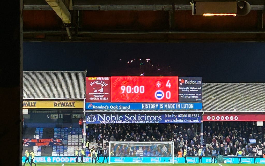 the Oak Stand score board reading Luton 4 Brighton nil