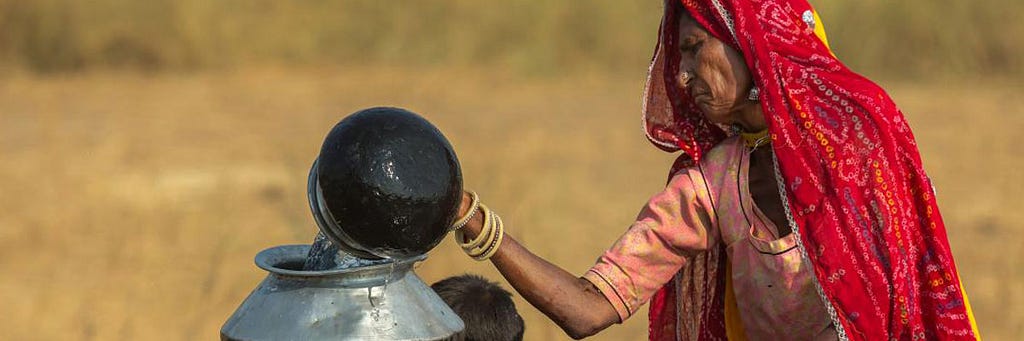 A woman in Pushkar, India, draws water from the well to take to her tent in the desert