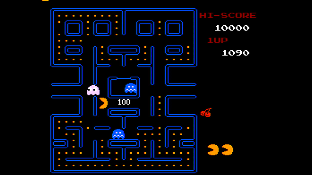 Screenshot of the arcade game Pac-Man. Pac-Man consumes a cherry and is rewarded with 100 points.