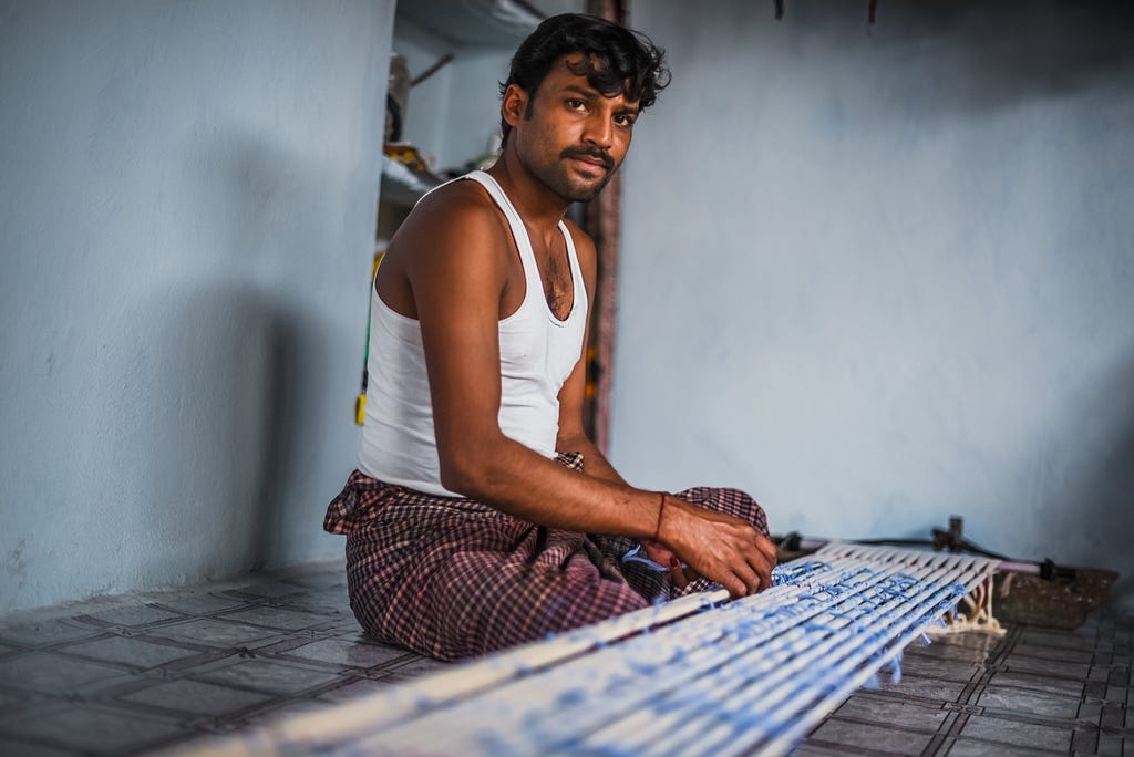 A man working on silk inside a shop