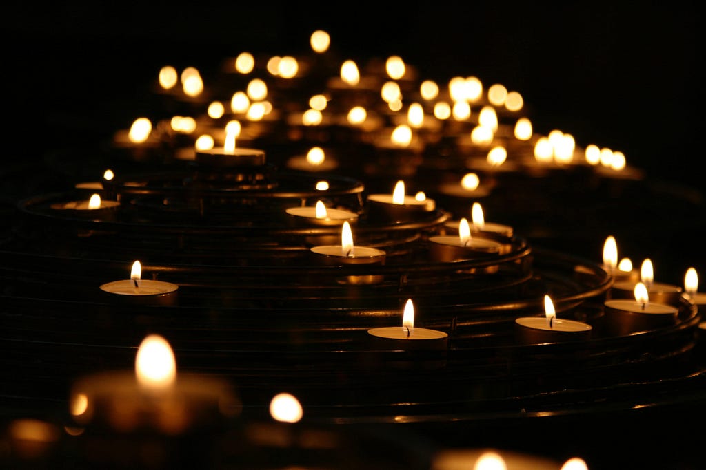 Photograph in night of small candles emitting flames