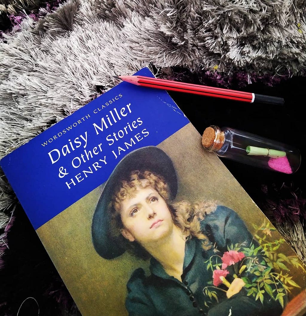 A book by Henry James titled Daisy Miller & other short stories along with a pencil and a message bottle.