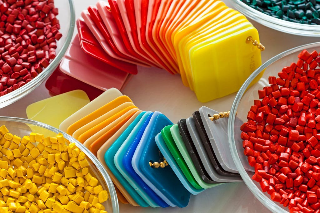 Injection molding plastic pellets and square color swatches help designers, engineers, and manufacturers understand the color, finish, gloss, and even texture of a potential finished product.