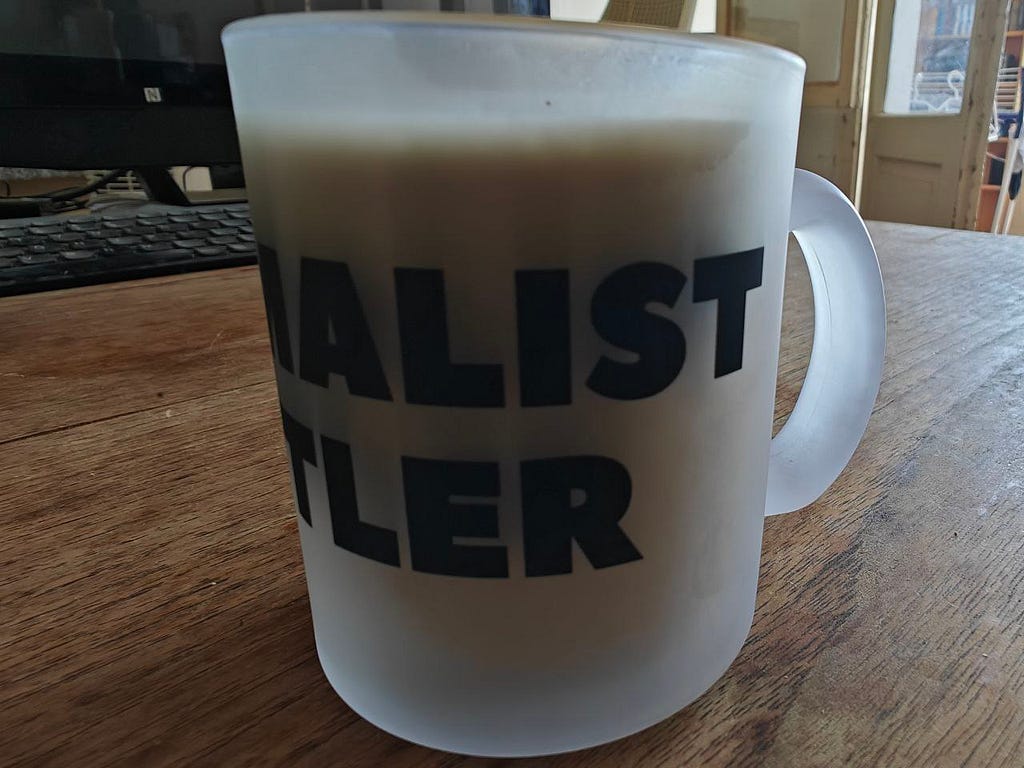 Awesome merch mug I won as a prize inside Minimalist Hustler Headquarters