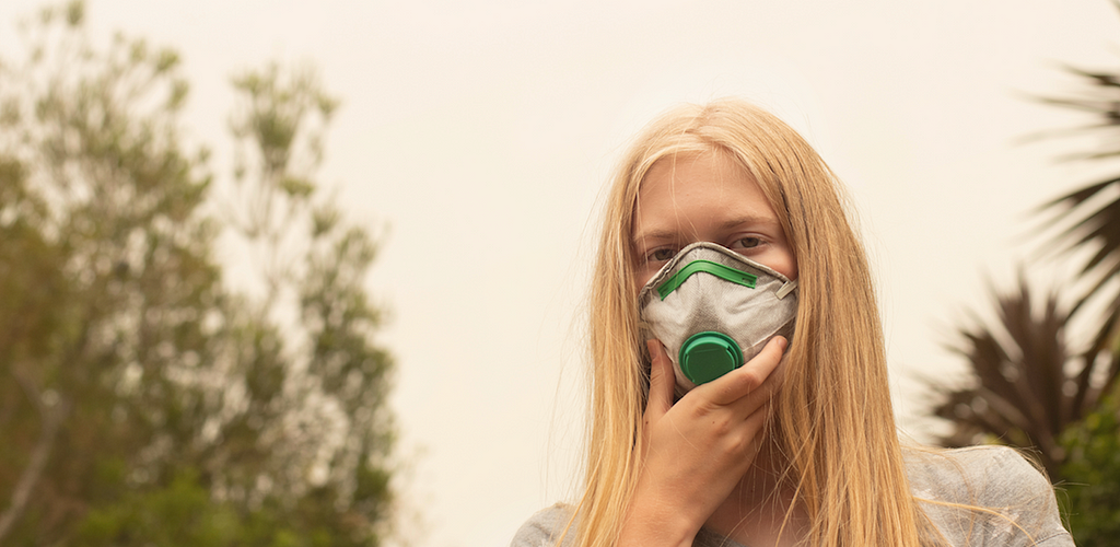 girl wears mask to protect herself from bushfire smoke