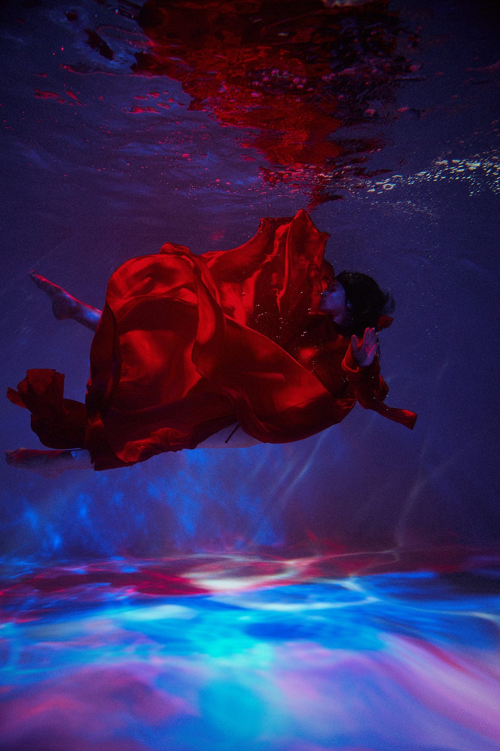 A woman with a red dress floating in the water