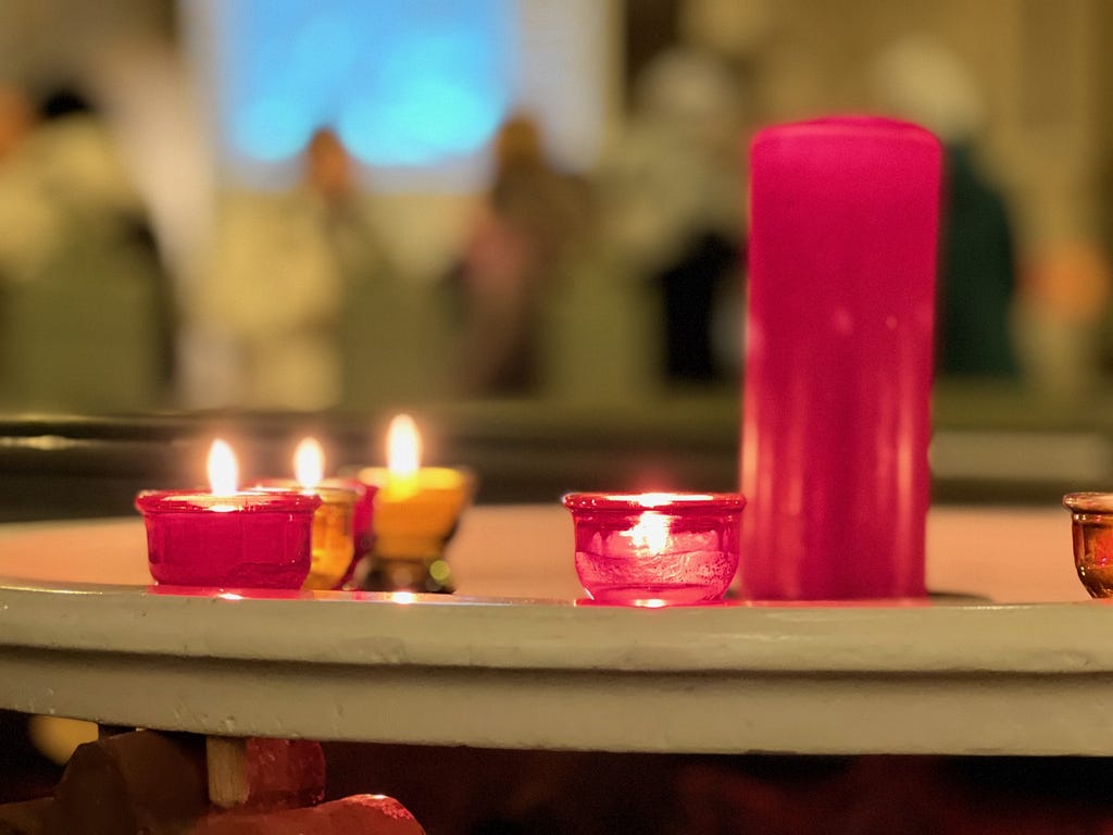 prayer candles burning on a tray