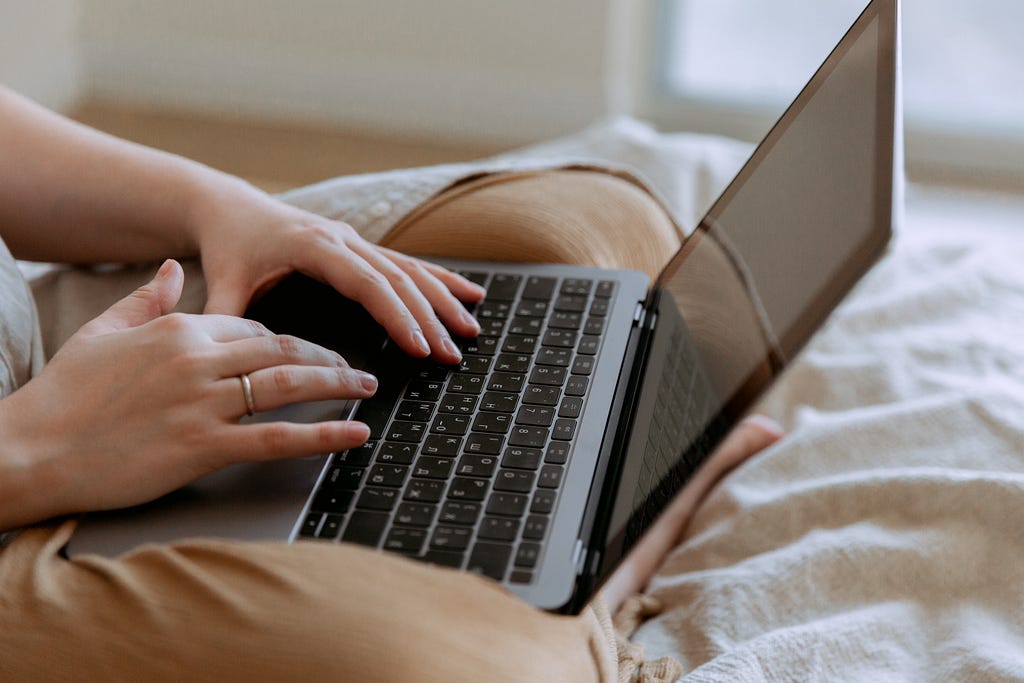 Woman using a laptop on the bed