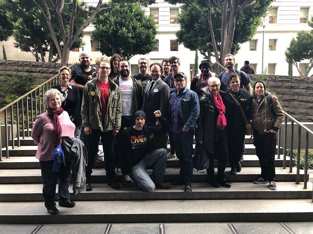 A group of people on stairs celebrate a court victory