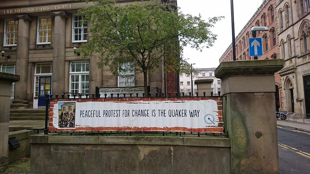 Banner outside Friends Meeting House, Manchester calling for peaceful protest