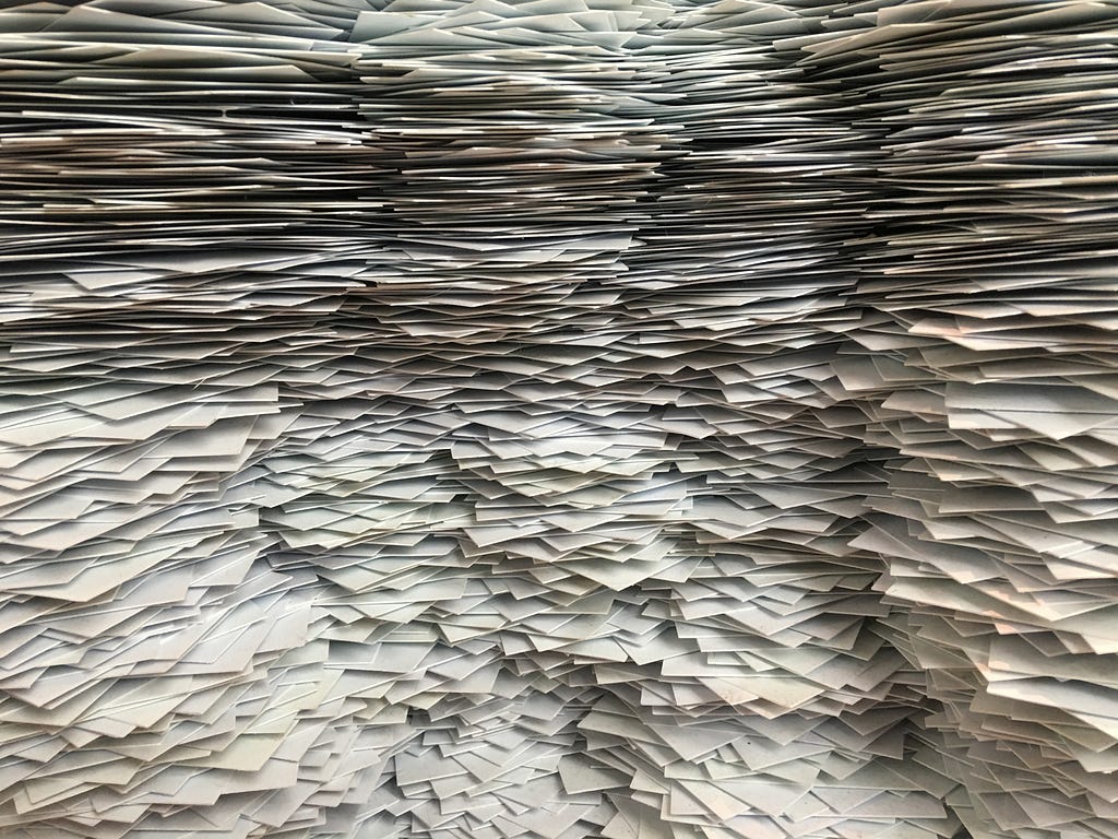 Fotografia com enormes pilhas de papéis, representando as mídias armazenadas.