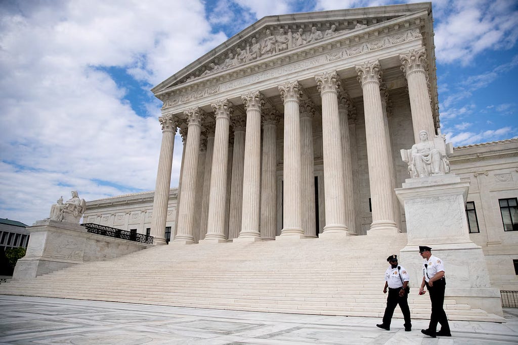Two cops walk outside the Supreme Court building