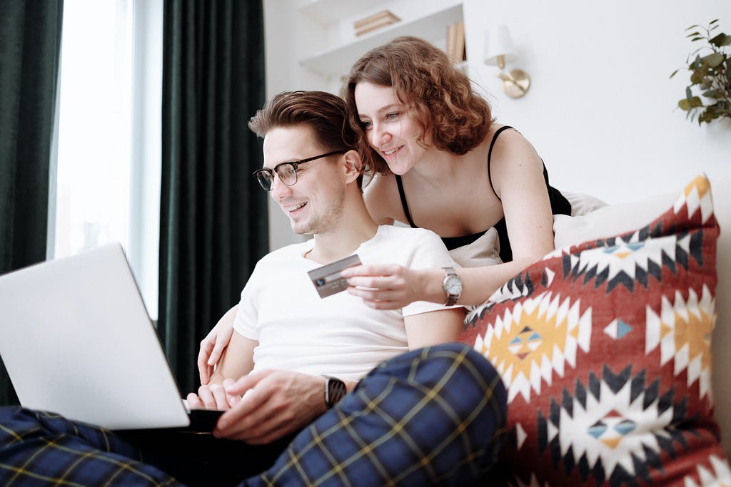 Man and Woman smilling while Shopping Online