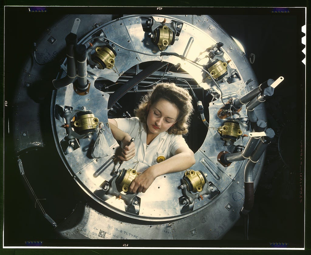 A photo of a woman assembling the cowling for one of the motors for a B-25 bomber.
