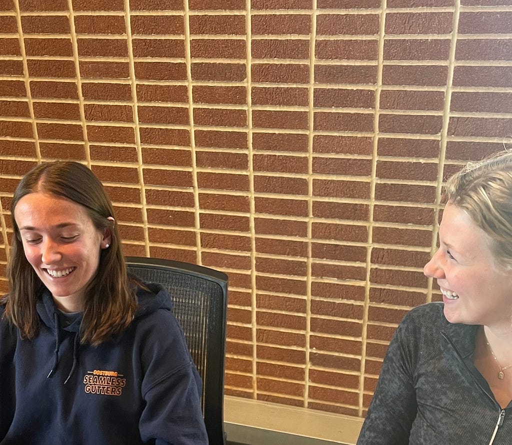 Going over volleyball statistics for their club volleyball team in Pius Xii Memorial Library is one of Ellie Cesarz and Katelyn Witte’s favorite activities to do together besides playing volleyball. They sit together on September 25, 2022, smiling as they reminisce about how one of their strategies last year led them to victory in a tough game.