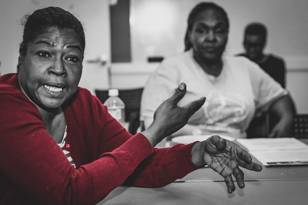 A photo of a woman in red talking.