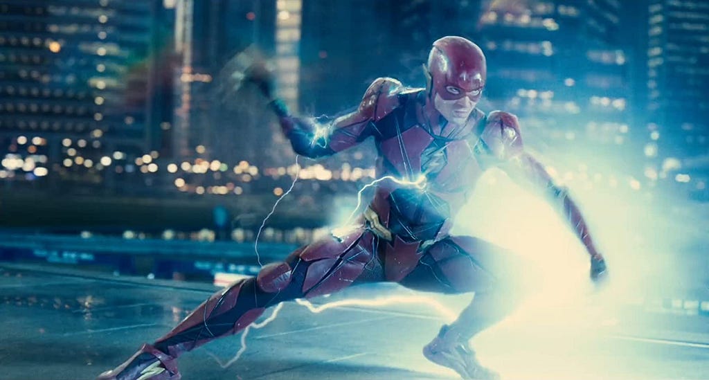 In ‘Justice League’ (2017), The Flash, played by Ezra Miller, is ready to power up. Blue electricity bolts surround him.