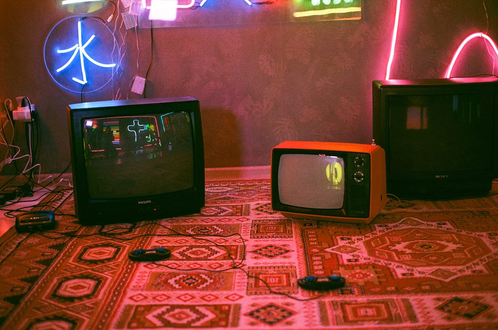 televisões e videogame em cima de um tapete