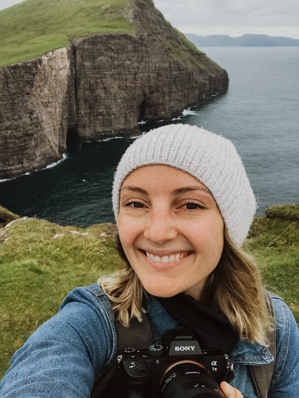 Me with my camera on a cliffside hike in the Faroe Islands