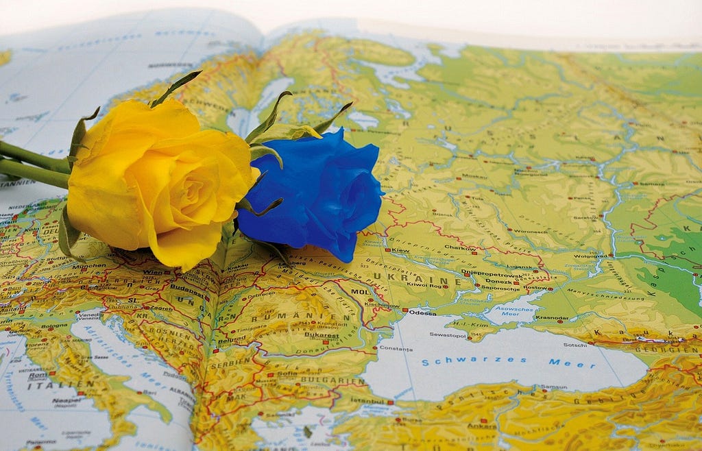 yellow and blue roses resting on a map of Ukraine.