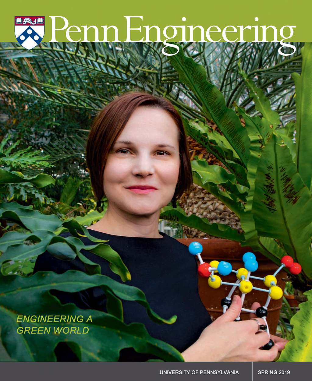 Aleksandra Vojvodic stands in a greenhouse, holding a model of a catalysis reaction.