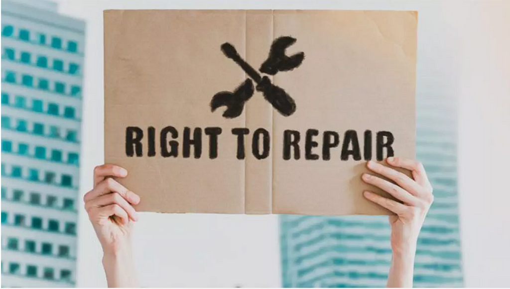 Two hands holding up a sign with the words Right to Repair stencilled on them