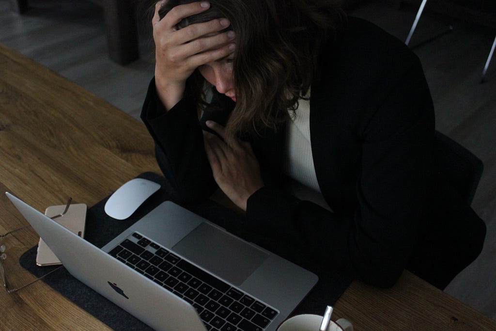 Sad lady working — Signs Your Self-Esteem is Sabotaging Your Career