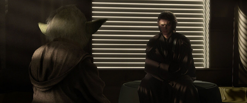Anakin Skywalker asks Yoda for advice during Revenge of the Sith (this goes poorly). He is in shadow, the blinds behind him painting him in shades of light and dark to foreshadow his coming fall from grace.