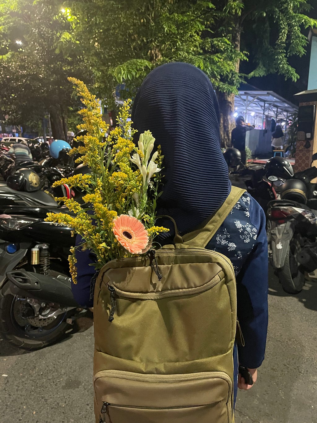 Salah satu peserta angkatan 3 BISINDO Renjana dengan bunga rampai yang dia masukkan ke dalam tas punggungnya