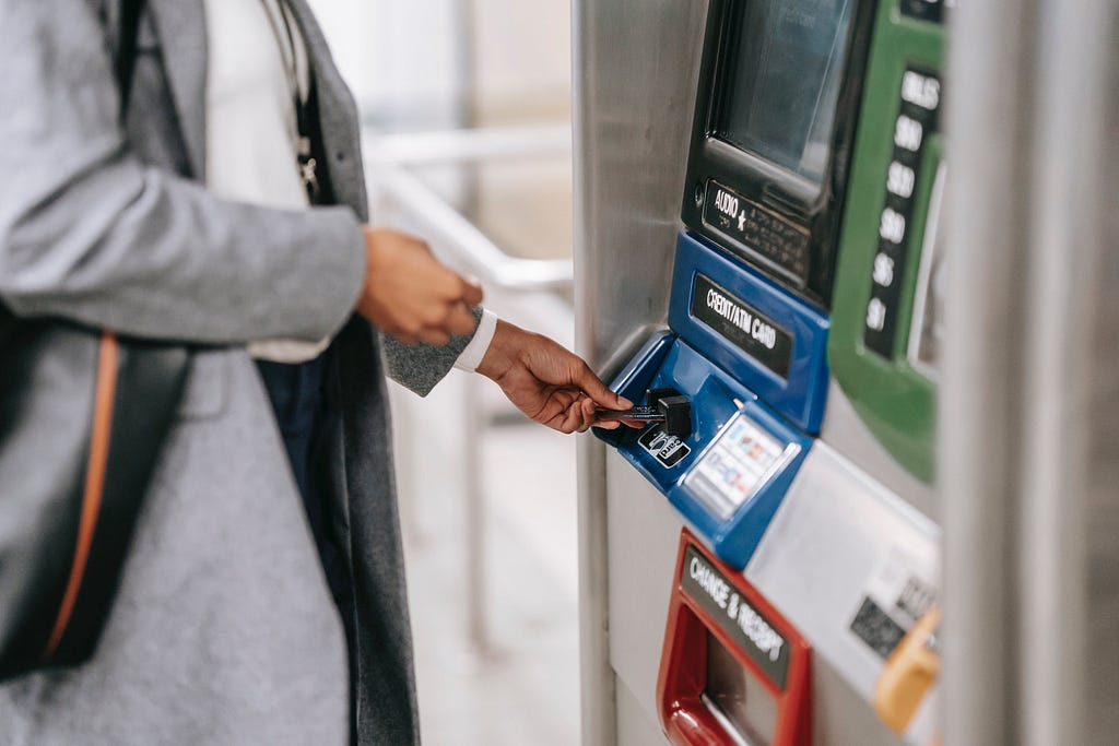 A person inserting a card on an ATM.