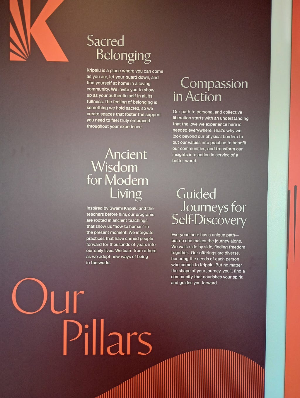 A poster stating the “Spiritual Pillars” of the Kripalu Center for Yoga and Health: Sacred Belonging; Compassion in Acton; Ancient Wisdom for Modern Living; and Guided Journeys for Self-Discovery.”