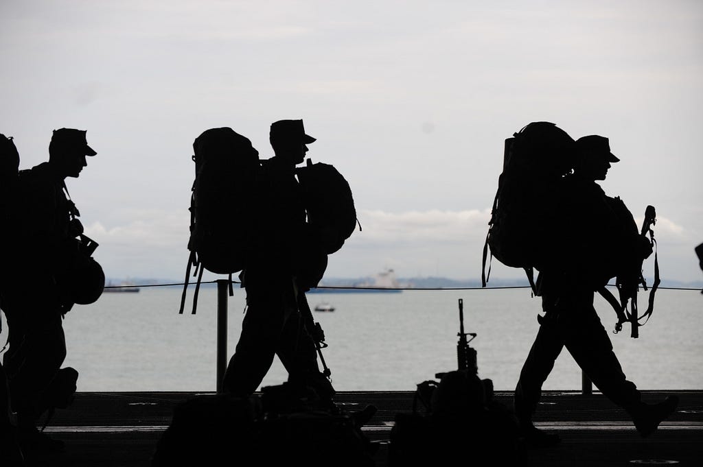 photo for James Goydos MD 2020 article ‘skin cancer-another causalty of war’. Photo of armed forces walking along the sea.