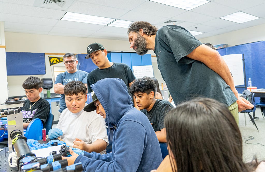 WWU Assistant Professor of Biology Nick Galati stands ready for questions as a group of Mount Vernon High School students works together to build a microscope.