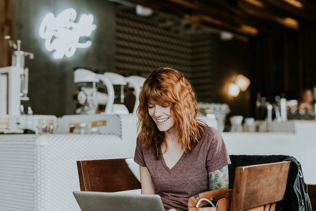 Girl on a laptop in a cafe. Image taken from unsplash