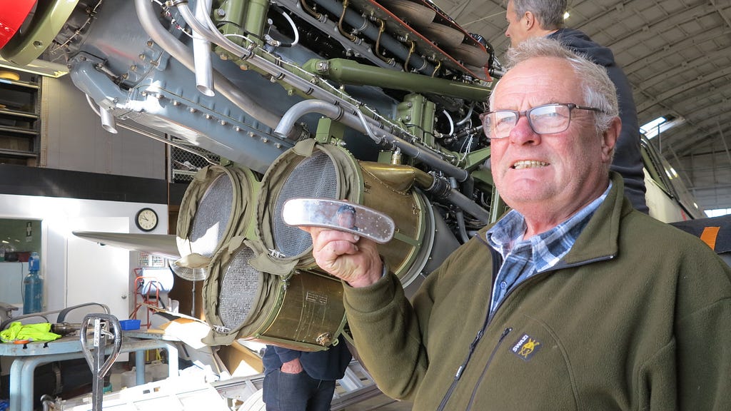 Peter Haigh holds a mirror from the war surplus Kitty Hawk that his father wrecked post-war. Behind him is the lend-lease Russian Kitty Hawk, White 51.